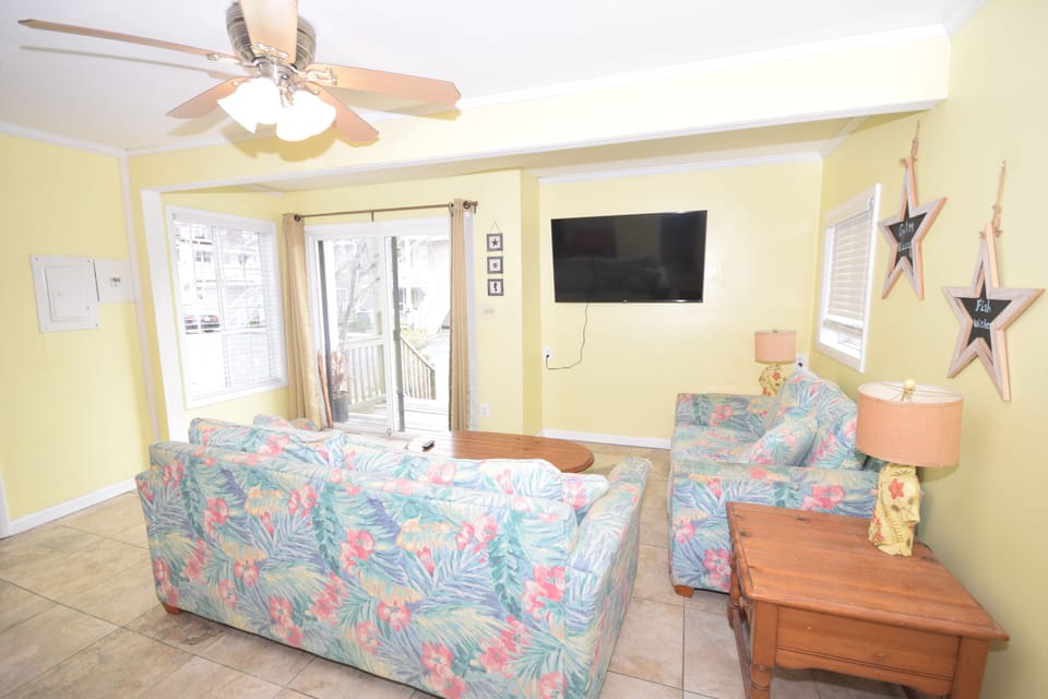Living and dining room with smart HDTV, tile floors, and slider to deck