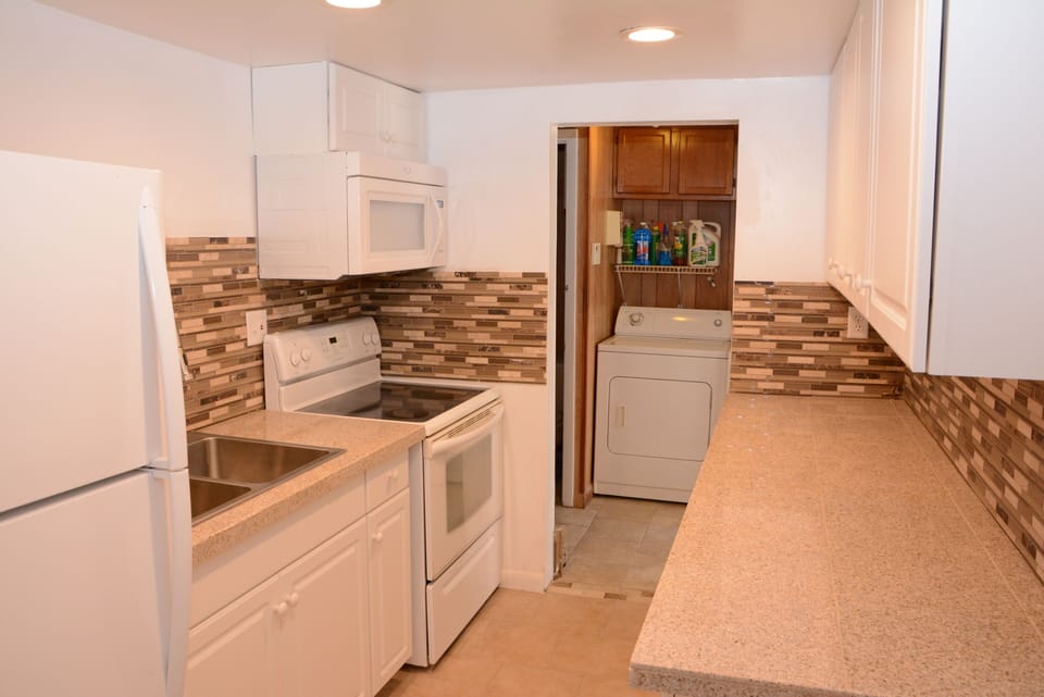 Beautiful kitchen with granite counters, tile floors and LED lighting.