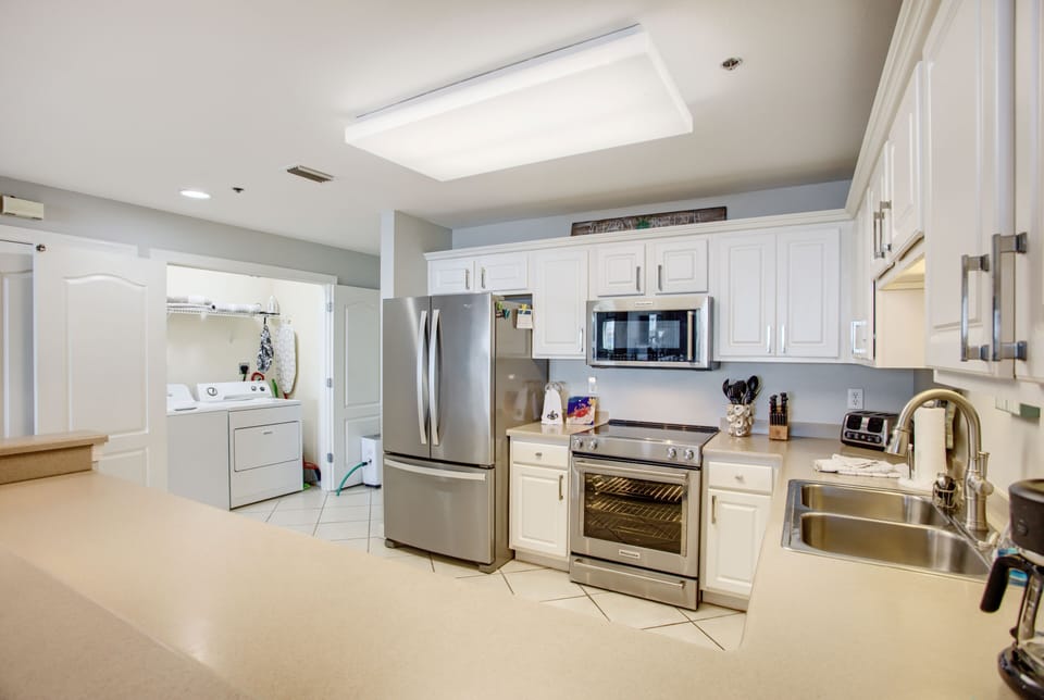 The laundry area can be seen in the rear. Full-size washer and dryer.