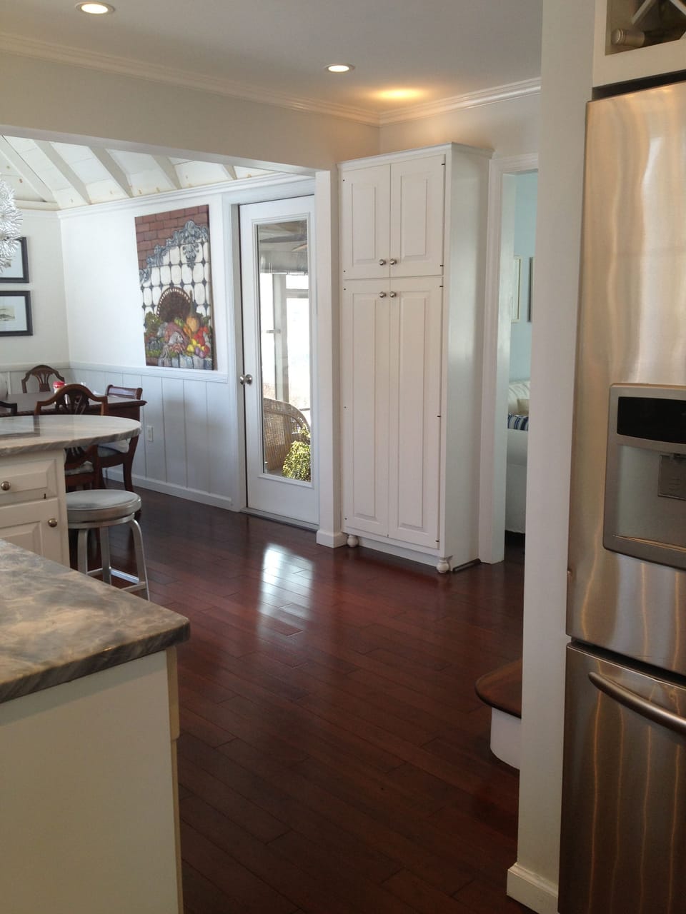 Open kitchen and dining with view to the screened porch through the glass door