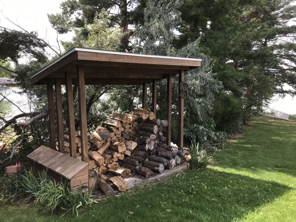 Fire wood supply w/ closed box for fire starting stuff & horse shoes on right.