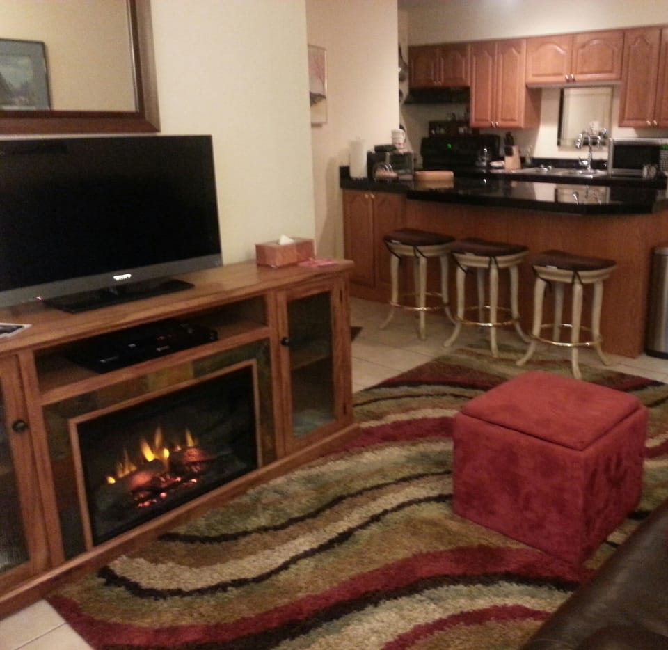 Living room has cozy electric warm-air fireplace 