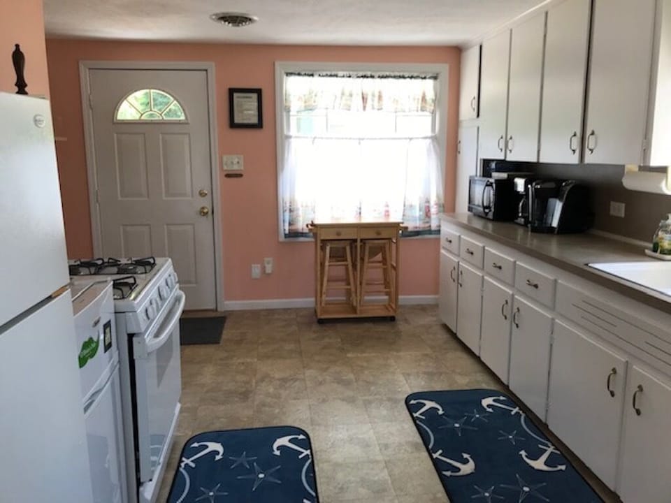 Kitchen view from LR includes a pull out table and stools for extra seating.