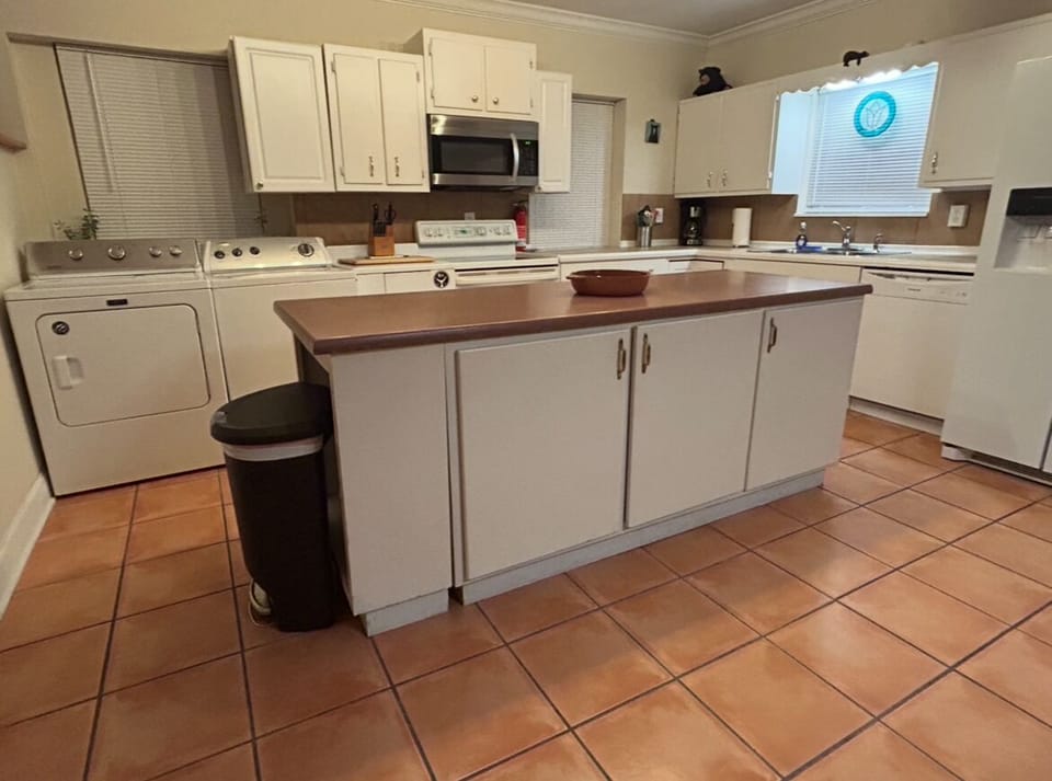 Kitchen island with washer and dryer in background 