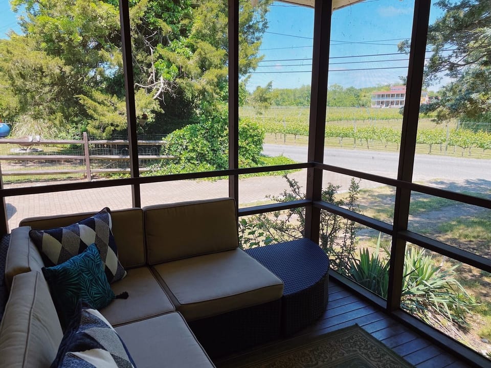 sitting area of mahogany front porch with Willow Creek Winery across the street