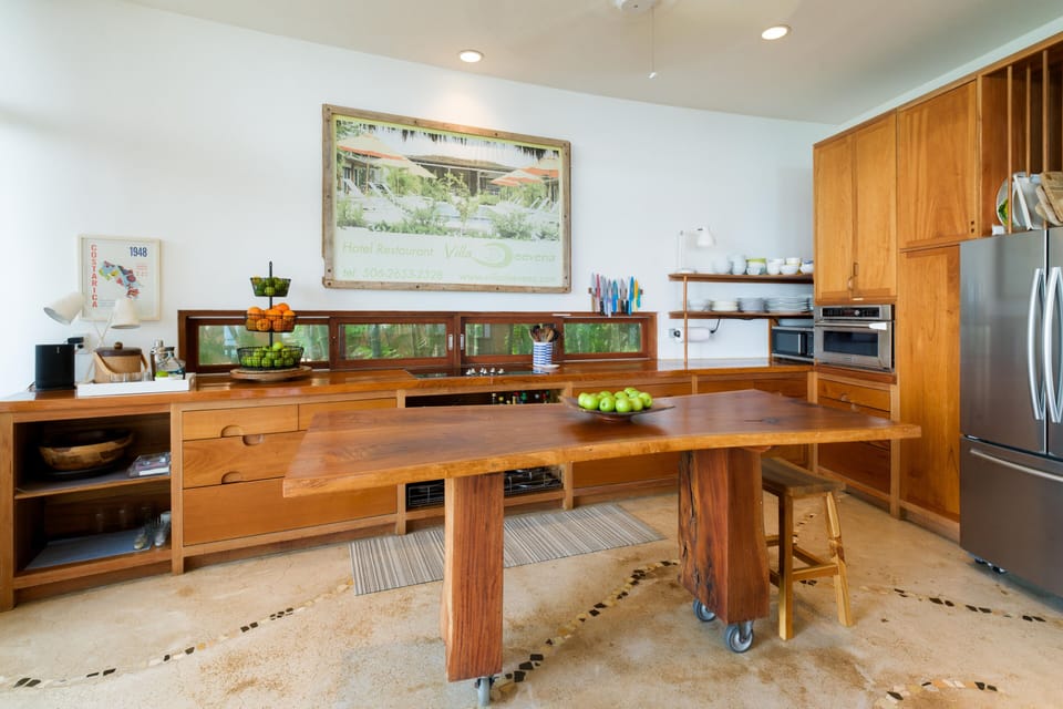 Curved guanacaste table in kitchen makes for easy traffic 