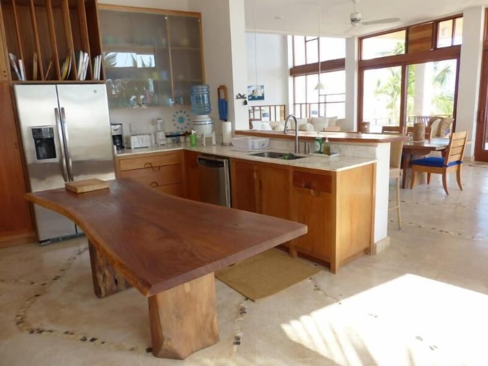 Open kitchen with quartz counters, stainless appliances, kitchen prep table