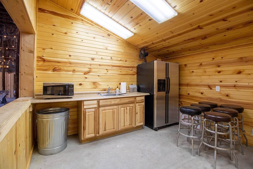 Barn kitchenette with sink, microwave, and fridge.