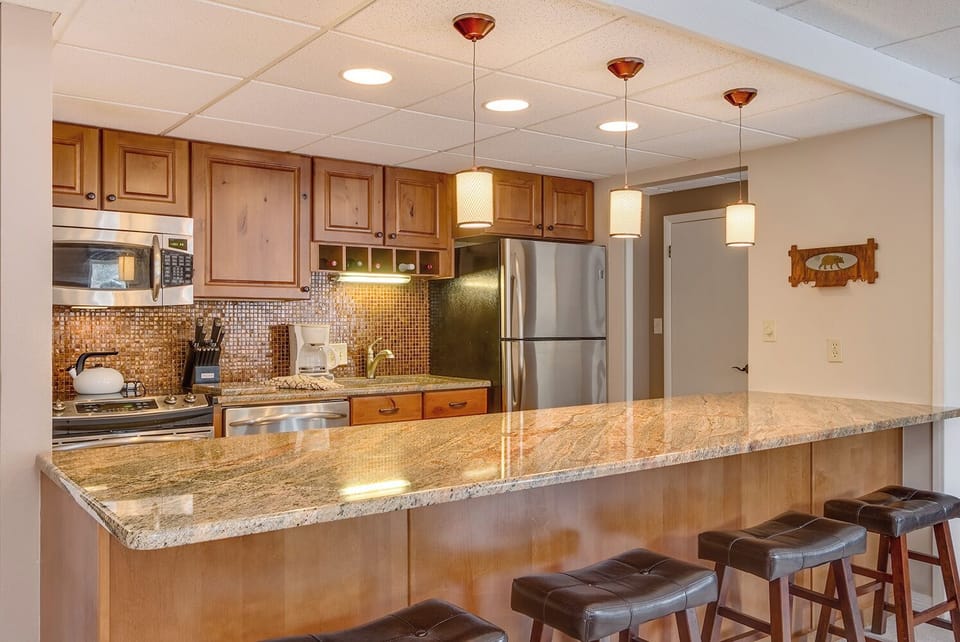 Updated fully-stocked kitchen with granite counter top and stainless appliances