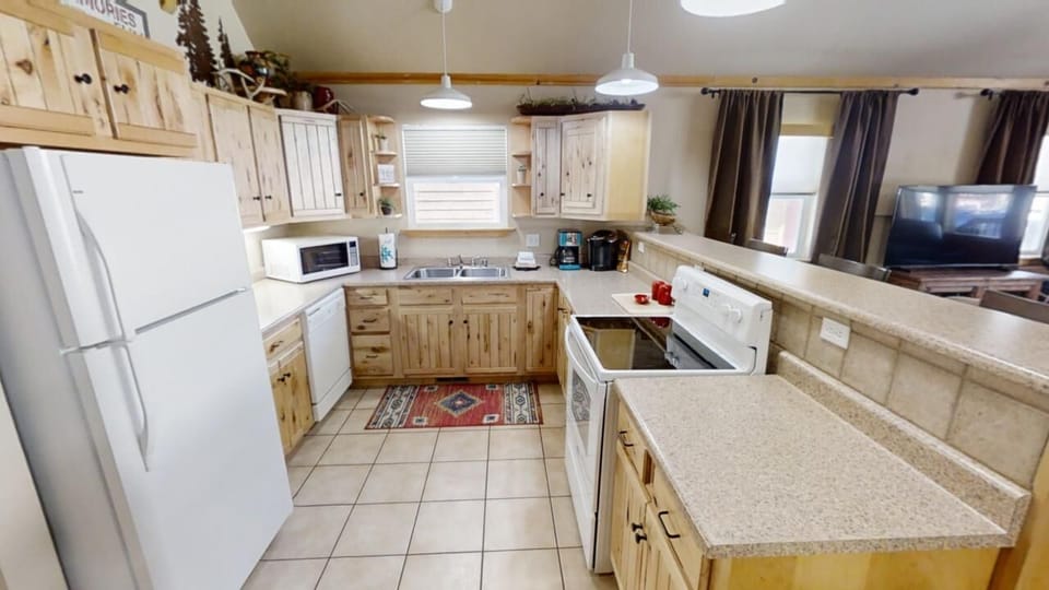 Your spacious kitchen welcomes you with warm wood cabinetry, modern appliances, and generous counter space—perfect for preparing your favorite meals or sharing morning coffee together.