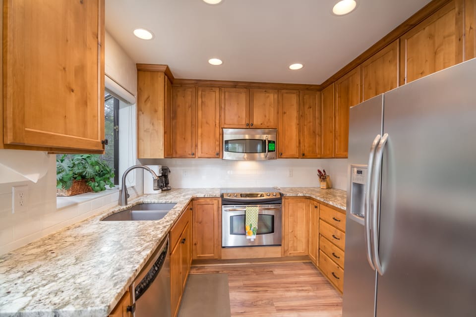 Kitchen has all stainless steel appliances, granite counters, and a granite sink