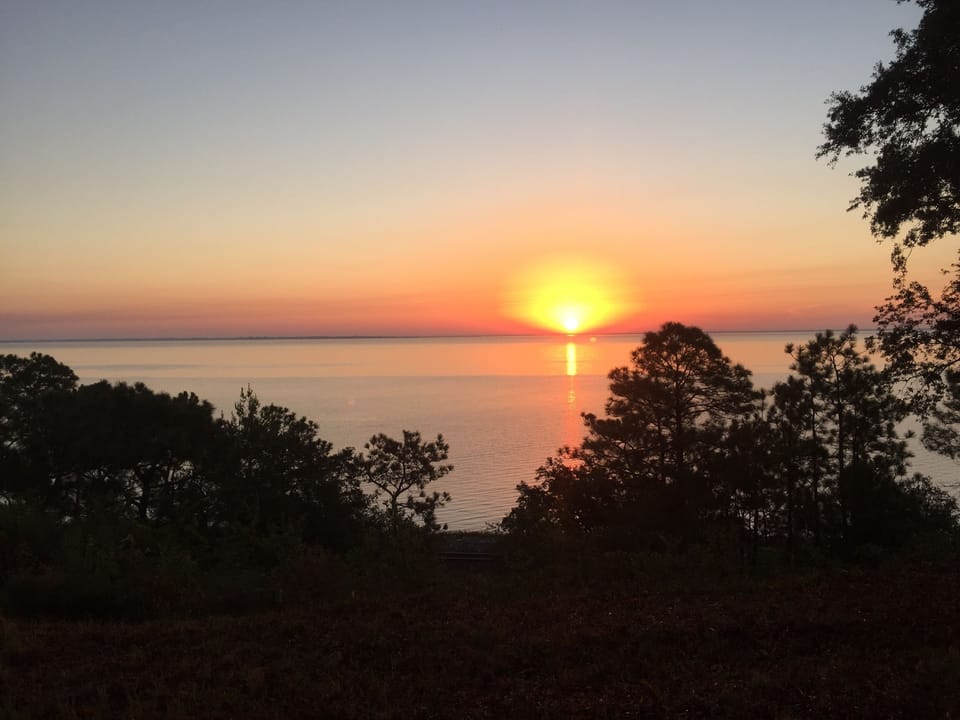 Sunrise over Escambia bay from nearby Scenic Bluffs. Pensacolascenicbluffs.org

