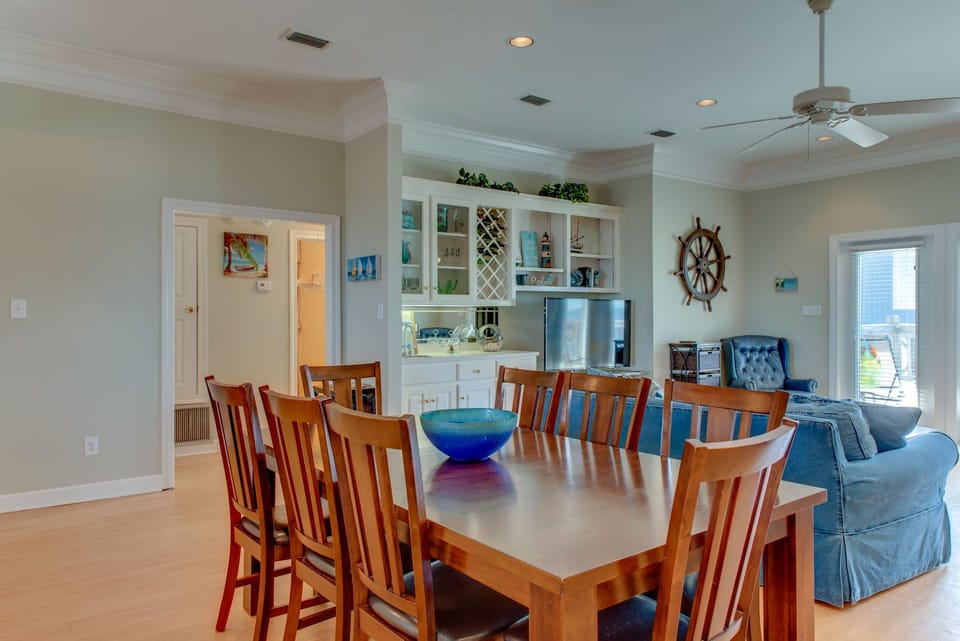 Gather around your spacious dining table for memorable meals with loved ones in this bright, coastal-themed space.