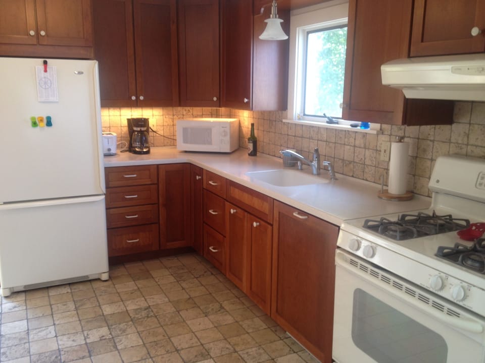 Kitchen with propane range, full size fridge, microwave, coffee maker