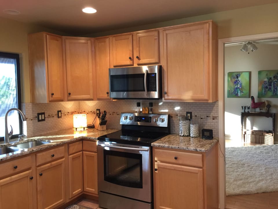 Kitchen looking out to pool and into den (use as 4th bedroom with pocket door)