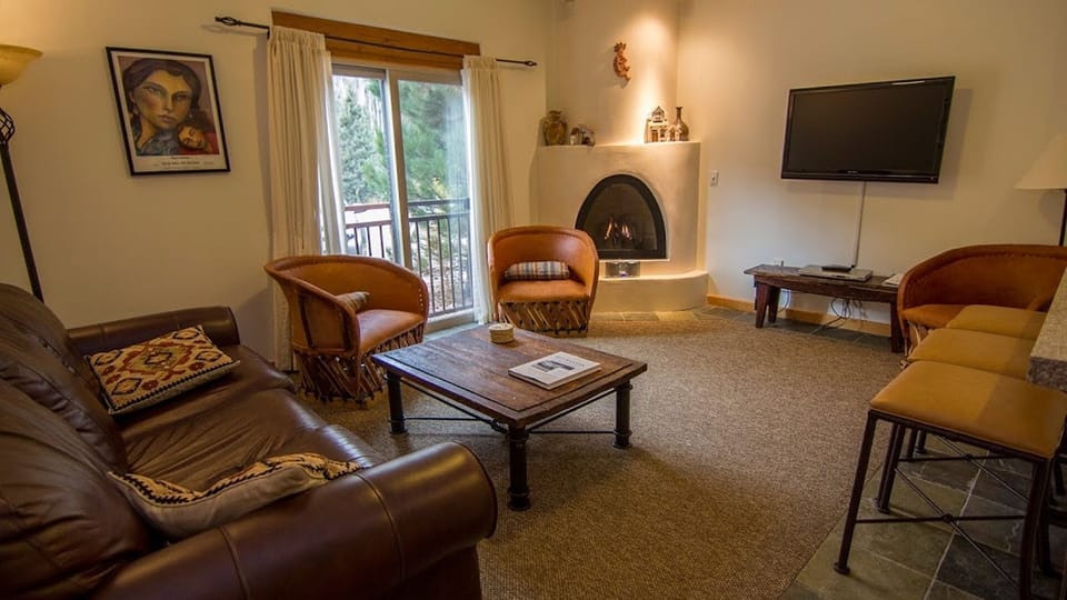 Lounge area with flatscreen TV and sleeper sofa plus 2 bar stools