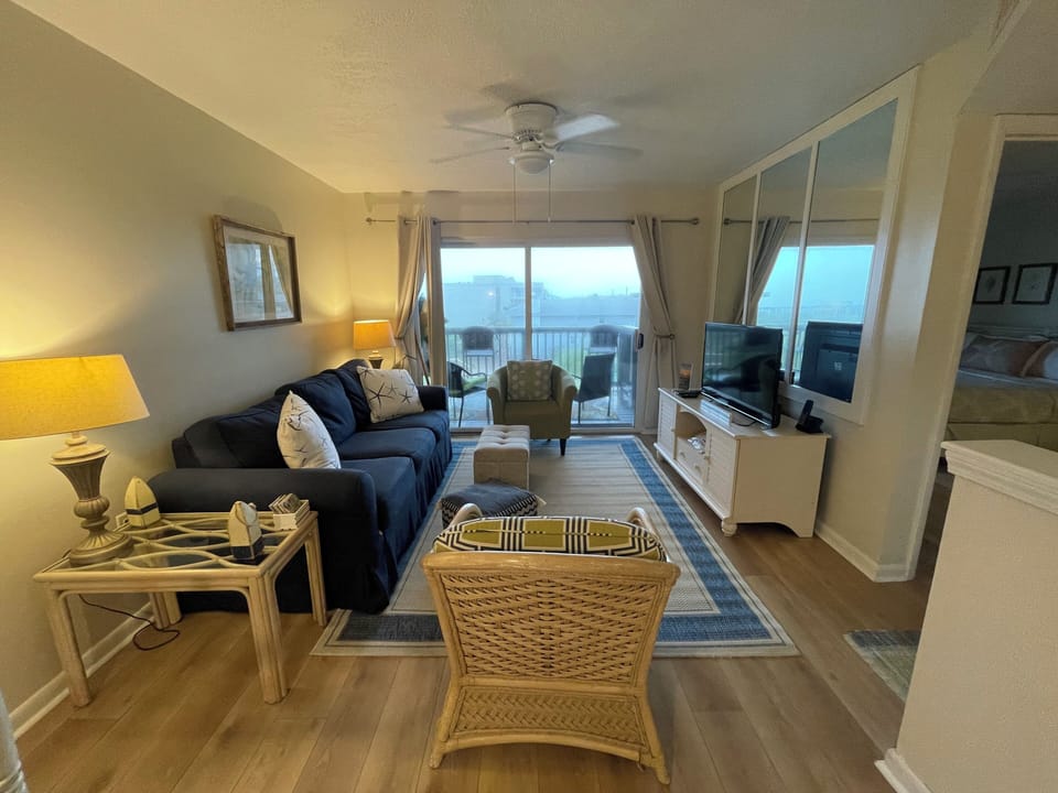 Living Room with sofa, two chairs, smart TV, games and books for entertaining