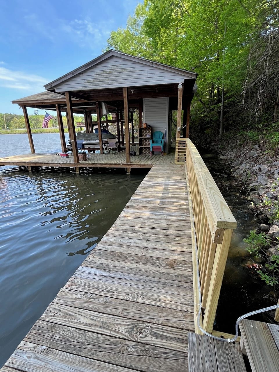 Walkway to private boathouse with swim ladder and boat lift.