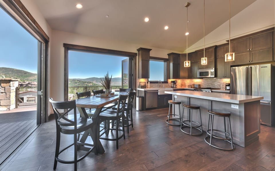 Dining for up to six at the table with additional seating at center island, balcony in season