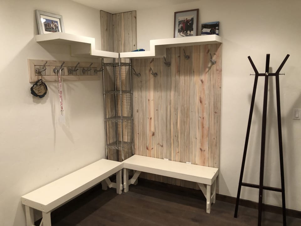 Mud room has hooks to hang clothes.  Bathroom with steam shower beside room.
