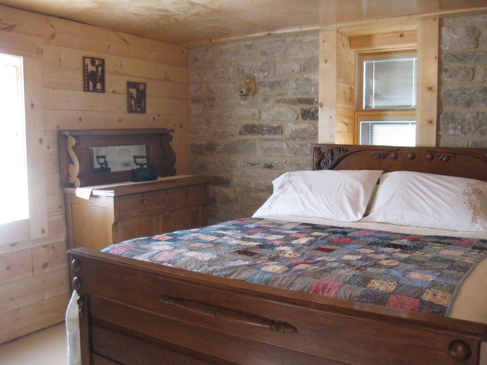 Queen bed in the original stone room, built in the 1860's.