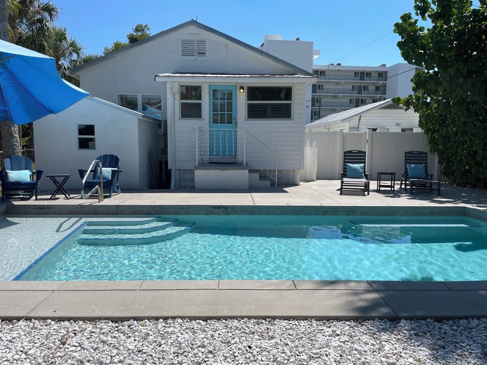 Private pool with sun shelf and view of back of Siesta Beach House 