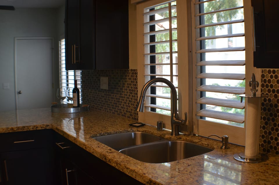 Kitchen area with granite counters and stylish backsplash