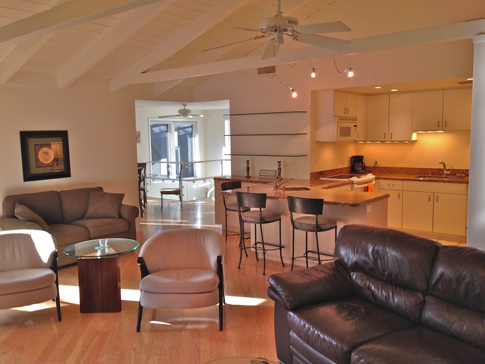 Another view of the great room and kitchen with the dining area and inside staircase just visible in the distance.