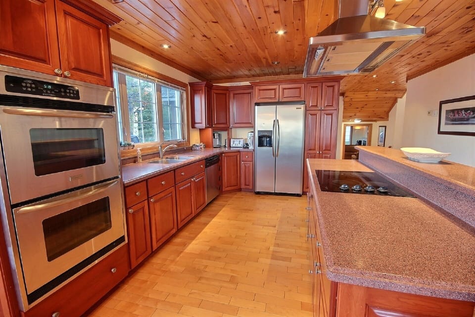 Fully stocked kitchen with double oven, place settings, pots, and pans