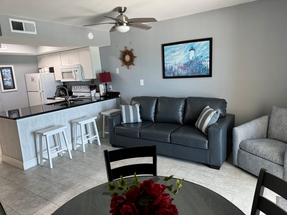 Dining table, living area seating, and kitchen with bar stools.