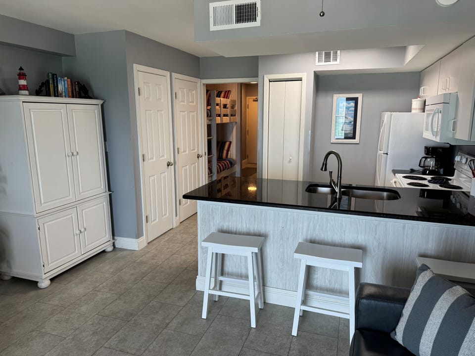 Looking through the kitchen area, down the hall toward the entry door.
