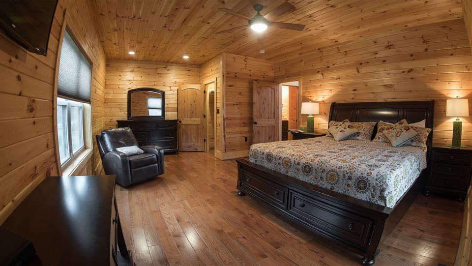 King bedroom with cedar lined dressers and flat screen TV