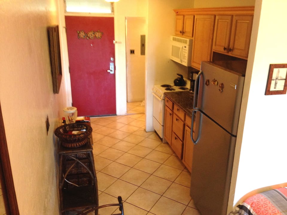 Kitchen with oven, stove, microwave, coffee machine, toaster and blender.