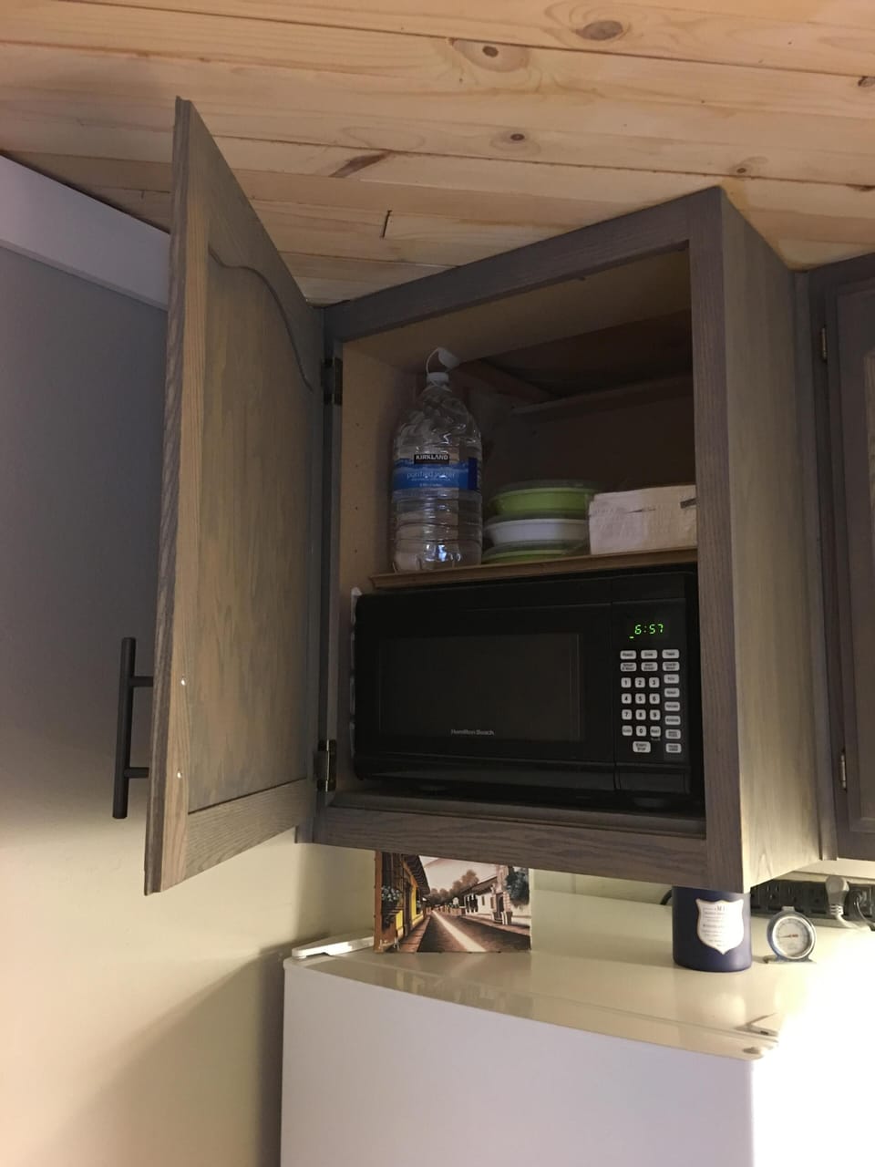 Microwave built into cabinet above fridge