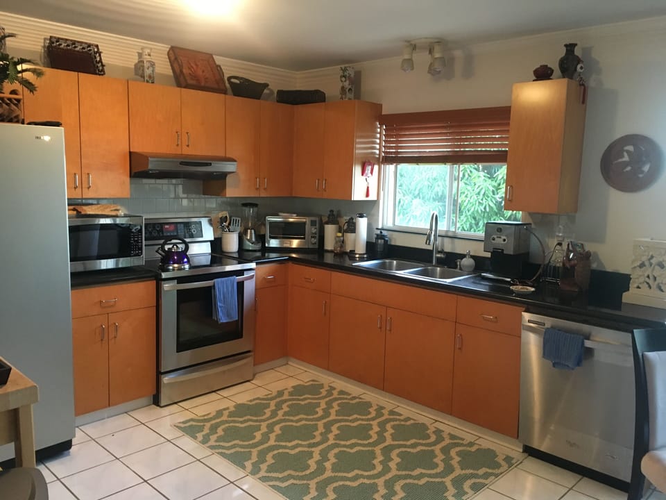 kitchen stocked with lots of glasses, pot pans, plates, coffee mugs, bowls ect