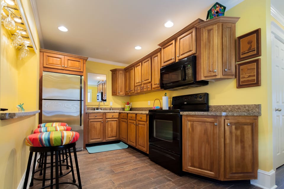 Galley kitchen, fully stocked with cooking utensils and plates