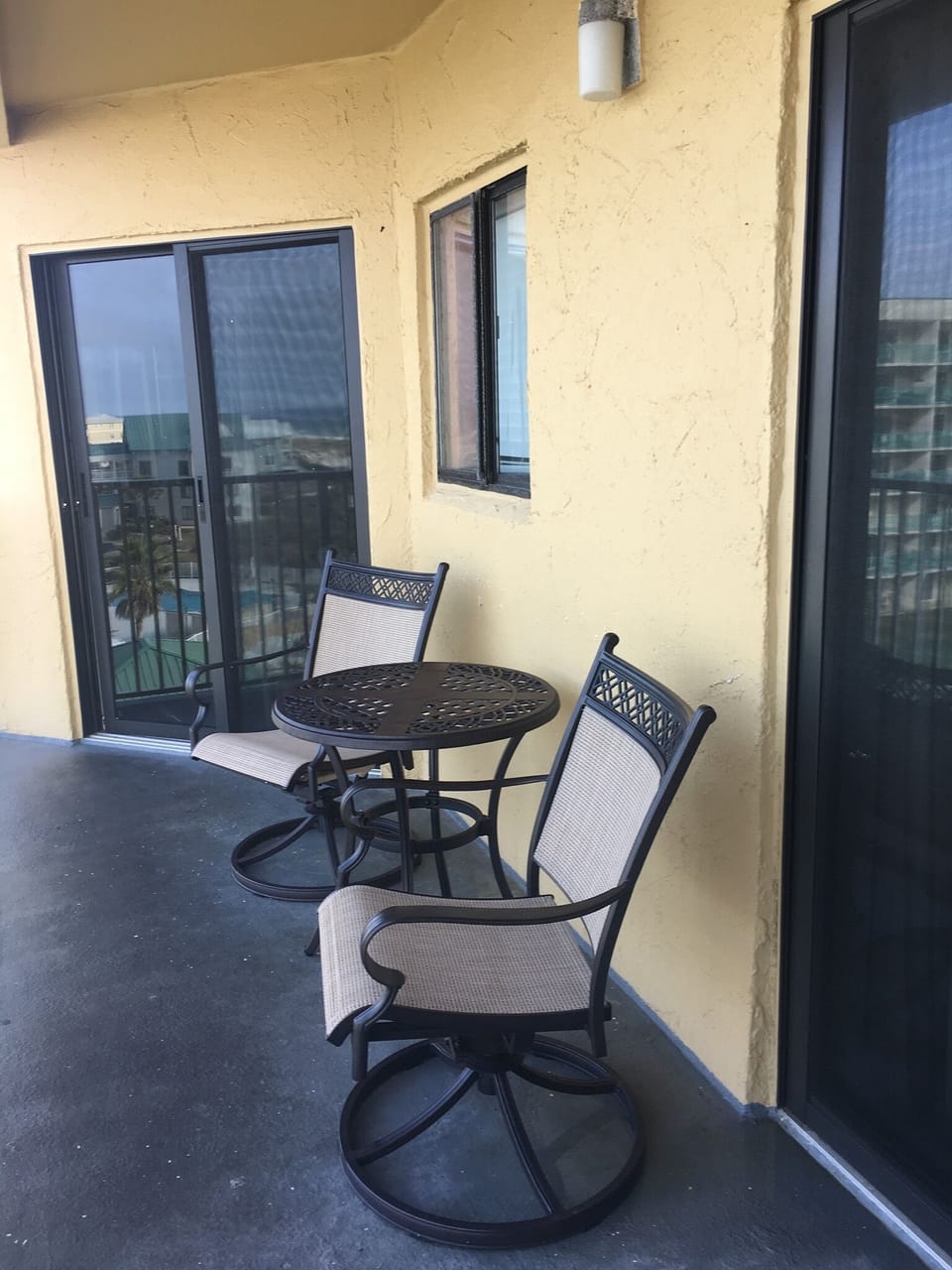Comfortable seating on balcony plus three stackable chairs. 