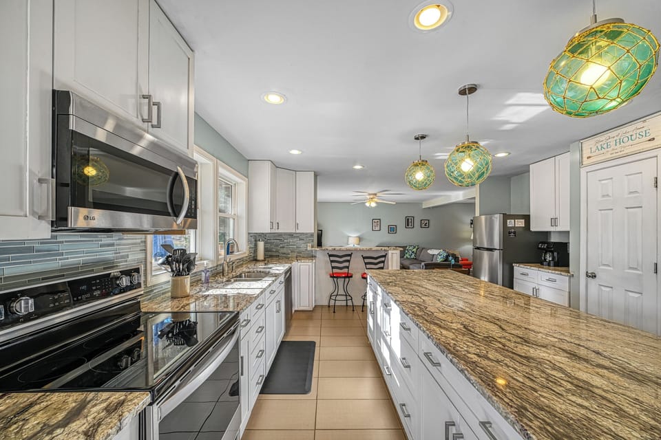 Electric stove, microwave, dishwasher, refrigerator with ice maker, coffee pot.