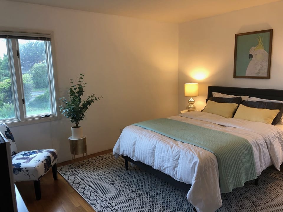 Downstairs primary bedroom with queen bed, futon sofa and outdoor patio access