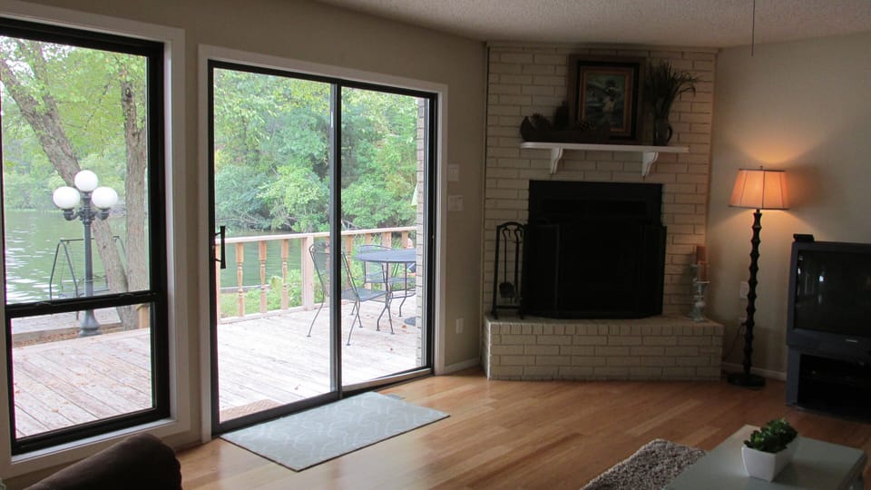 Living room with wood burning fire place looking out on to the lake
