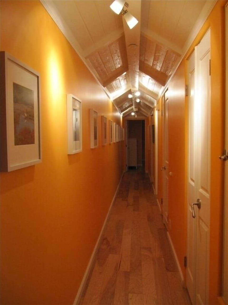 Art filled hallway to private bedrooms and baths.