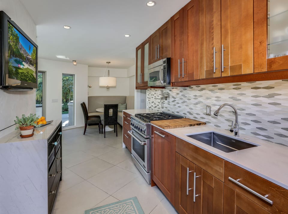 Galley kitchen with TV conveniently located near banquet dining cove