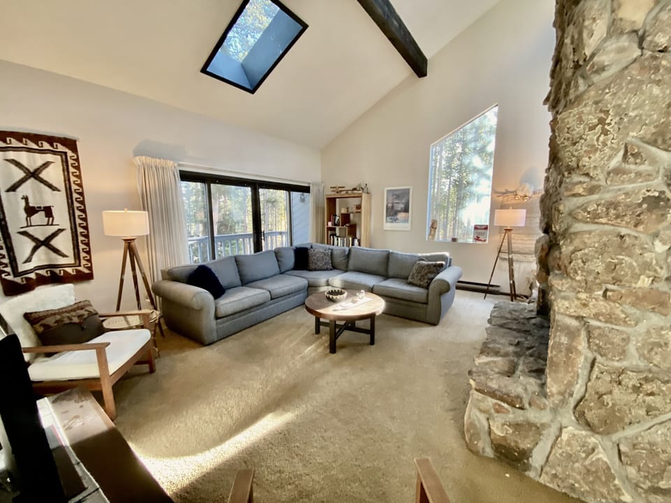 Living room, wood burning fireplace, open concept, high ceilings, natural light