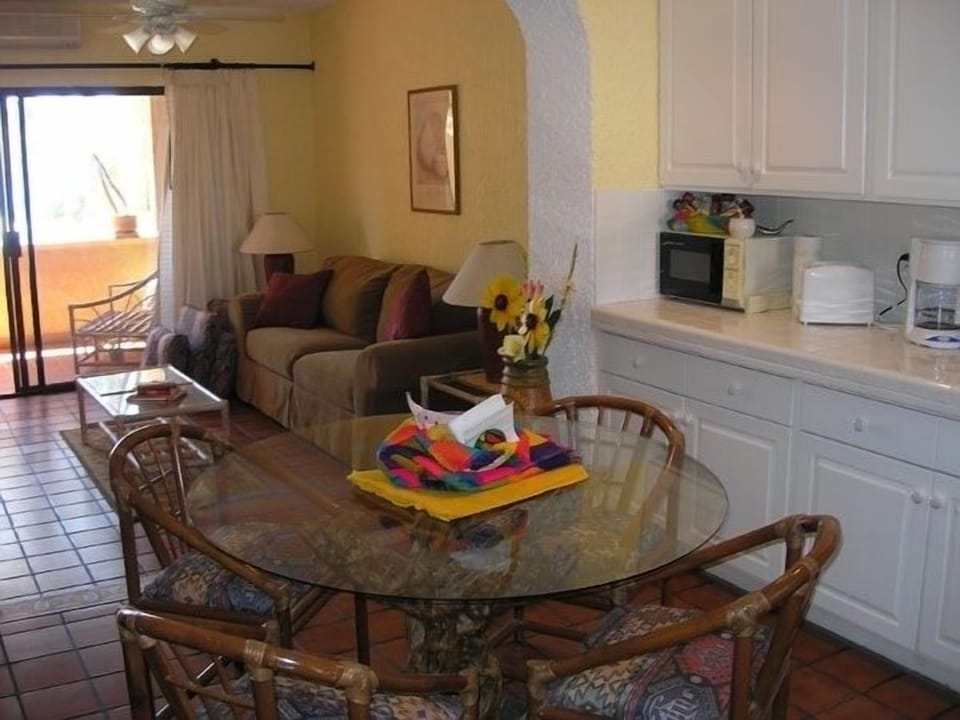 Roomy kitchen w/glass dining room table and four comfortable rattan chairs.