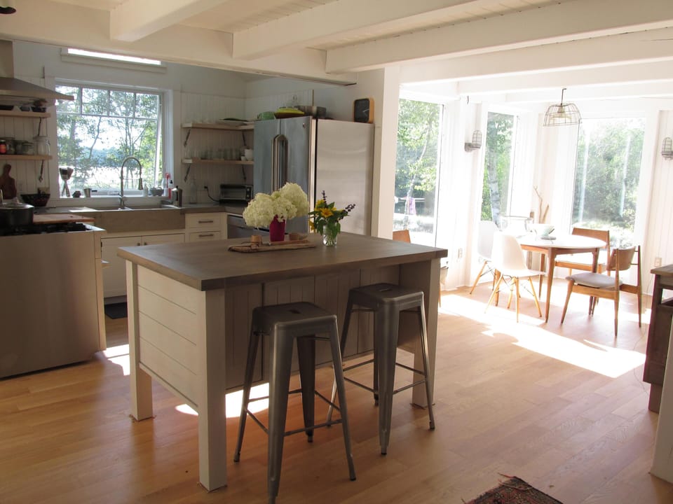 Large center island with additional seating. Dining room overlooking the cove .