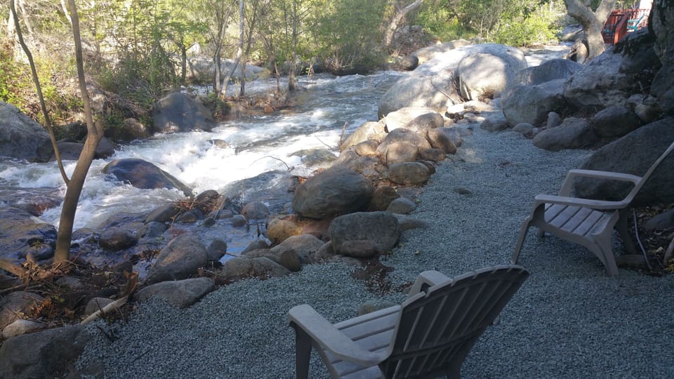 sit on a beach like setting on the river, in the shade.