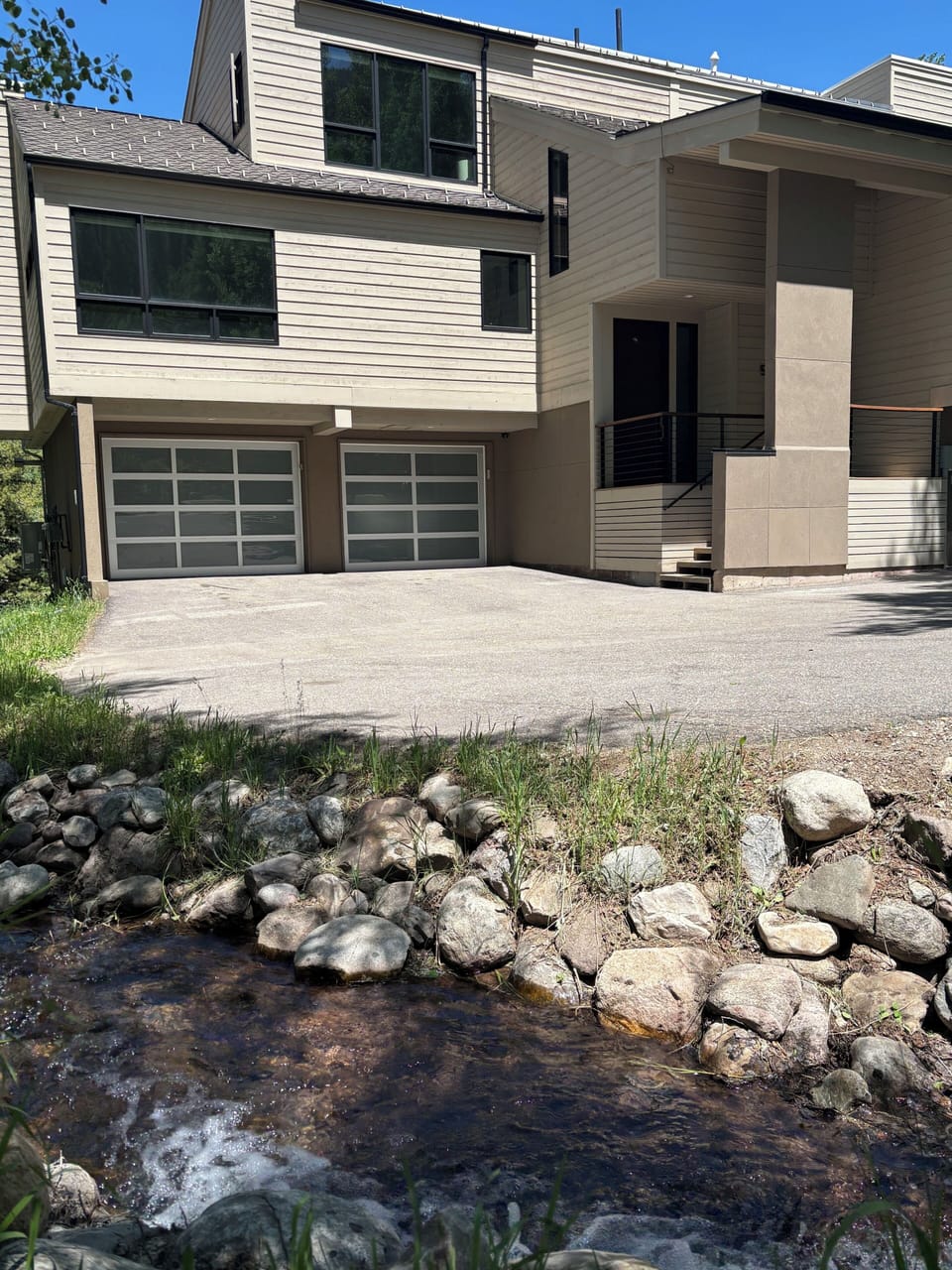 Exterior highlighting two car garage, seasonal stream and architectural elements