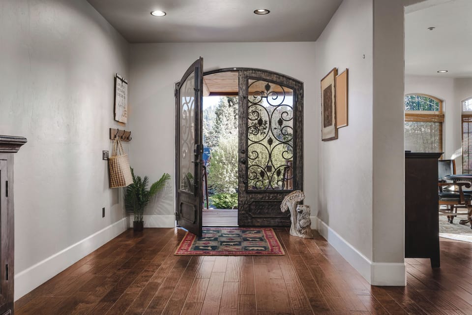 A welcoming entryway with elegant doors, hardwood floors, and timeless style!