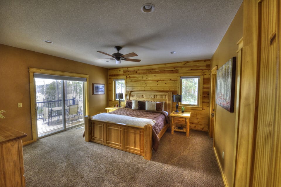 Master bedroom on main floor with king sized bed and deck access