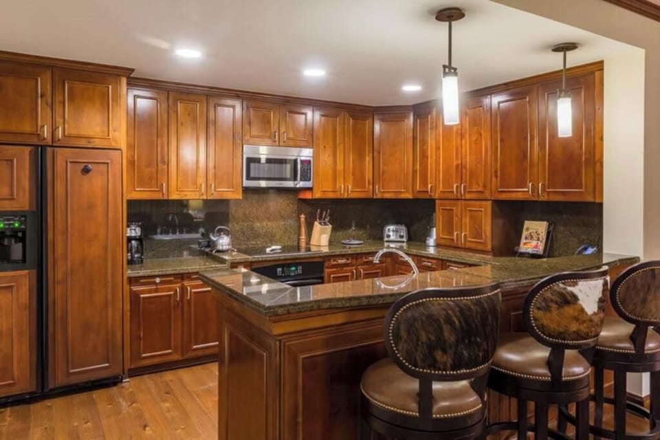 Gourmet fully equipped kitchen with formal dining table and bar seating